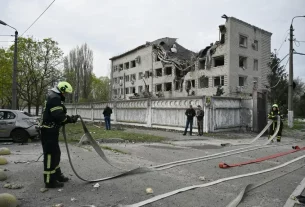 Пожежники працюють на місці події після російського удару по Києву 16 квітня