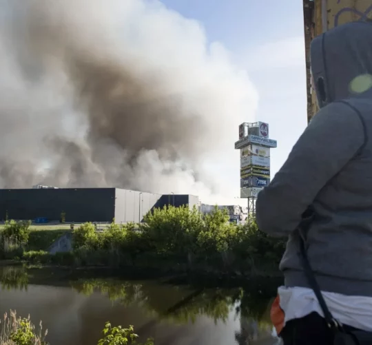 Польща: Людина дивиться на палаючий торговий центр «Marywilska 44» у Варшаві