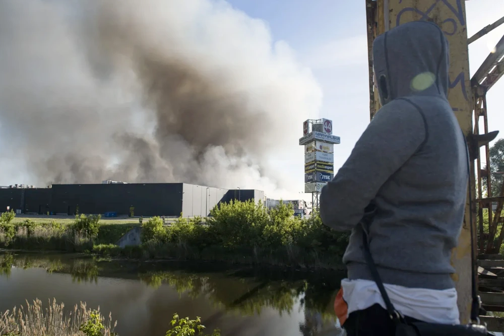 Польща: Людина дивиться на палаючий торговий центр «Marywilska 44» у Варшаві