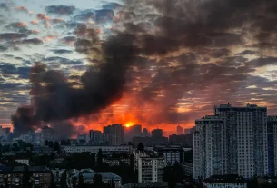 Після потужного російського авіаудару по Києву в Україні над містом на світанку в неділю, 24 травня 2026 року, піднімається дим