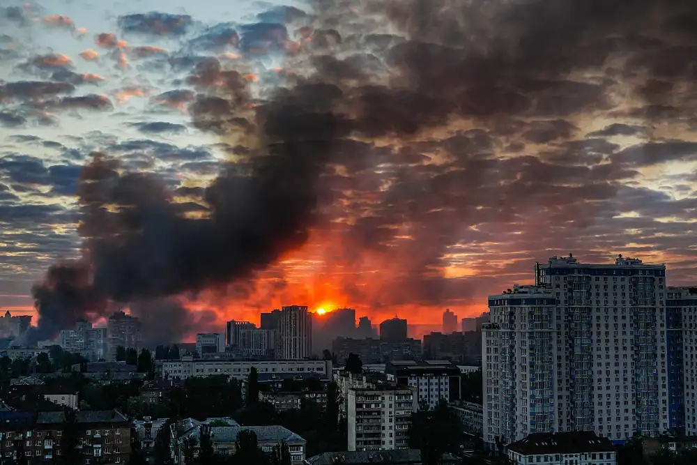 Після потужного російського авіаудару по Києву в Україні над містом на світанку в неділю, 24 травня 2026 року, піднімається дим