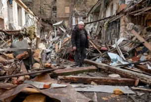 24 квітня в Одесі (Україна) поранений мешканець стоїть на місці житлового будинку, що зазнав удару російського безпілотника