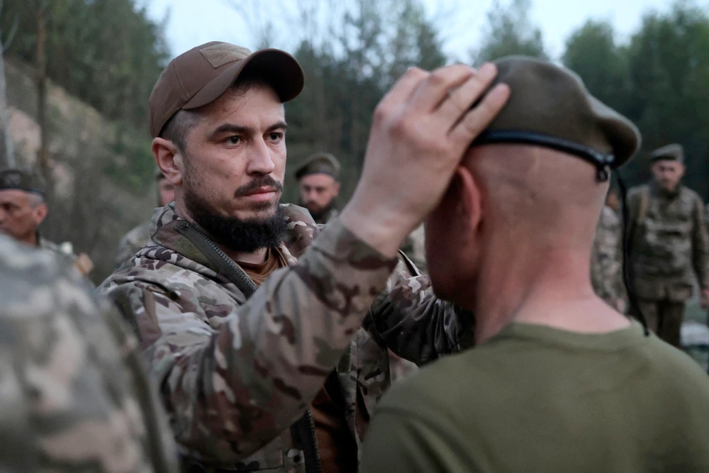 Український командир вручає своєму солдату берет за успішне закінчення курсу кадетів.