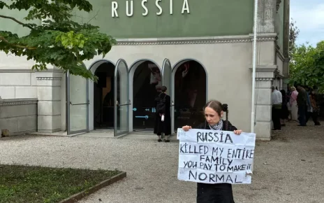 Українська протестувальниця перед закритим російським павільйоном у день офіційного відкриття Бієнале для публіки