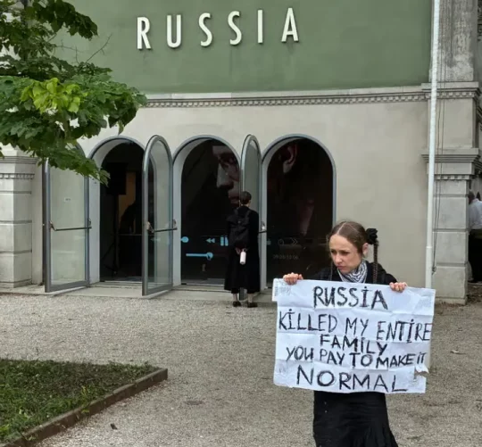 Українська протестувальниця перед закритим російським павільйоном у день офіційного відкриття Бієнале для публіки