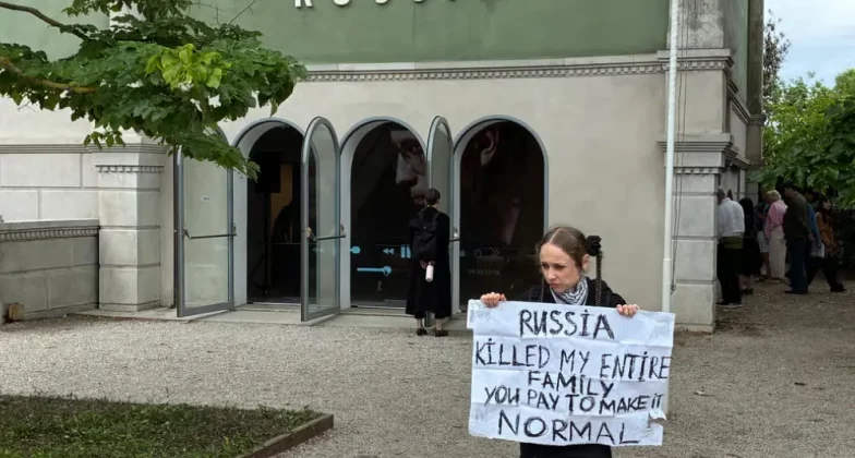 Українська протестувальниця перед закритим російським павільйоном у день офіційного відкриття Бієнале для публіки