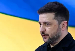 Володимир Зеленський на фоні українського прапору