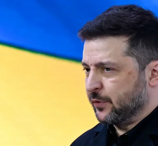 Володимир Зеленський на фоні українського прапору