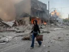 Дівчина йде по дорозі зруйнуваного району Лук'янівка після ракетних ударів Росії по місту Київ, 24 травня 2026 року.