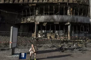 Хлопчик грає на баяні біля зруйнованого центру "Квадрат" на Лук'янівці