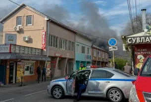 Російські поліцейські забезпечують безпеку території, поки дим піднімається після недавньої атаки безпілотника на нафтопереробний завод Туапсе в Туапсе, Краснодарська область, Росія, 29 квітня
