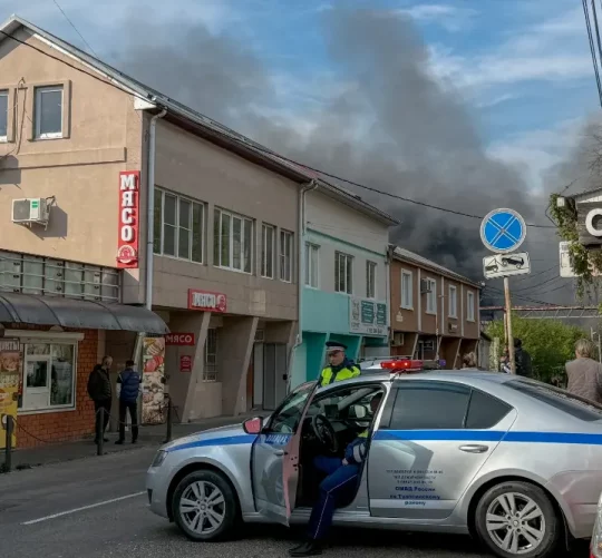 Російські поліцейські забезпечують безпеку території, поки дим піднімається після недавньої атаки безпілотника на нафтопереробний завод Туапсе в Туапсе, Краснодарська область, Росія, 29 квітня
