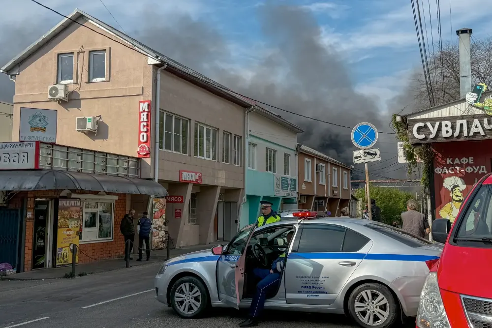 Російські поліцейські забезпечують безпеку території, поки дим піднімається після недавньої атаки безпілотника на нафтопереробний завод Туапсе в Туапсе, Краснодарська область, Росія, 29 квітня