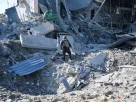 Правоохоронець оглядає кратер біля зруйнованої будівлі заводу з виробництва парфумів та косметики після ракетного обстрілу 18 квітня 2025 року в Харкові, Україна