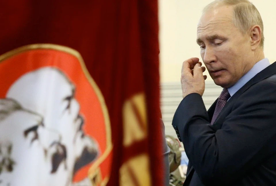 Володимир Путін проходить біля прапорів з фото Леніна та Сталіна