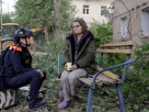 Психолог з надання екстреної допомоги розмовляє з потерпілою мешканцем на місці житлового будинку, що зазнав російського авіаудару у Харкові, 20 червня 2026 року