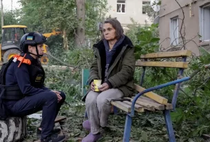 Психолог з надання екстреної допомоги розмовляє з потерпілою мешканцем на місці житлового будинку, що зазнав російського авіаудару у Харкові, 20 червня 2026 року
