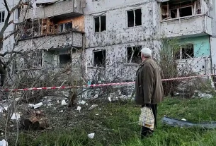 Мешканець оглядає місце російського ракетного удару, який влучив у житловий будинок у Києві, Україна, у вівторок, 2 червня 2026 року.