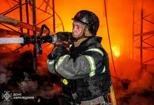 Український пожежний гасить пожежу після удару Росії ракетами по місту Харків
