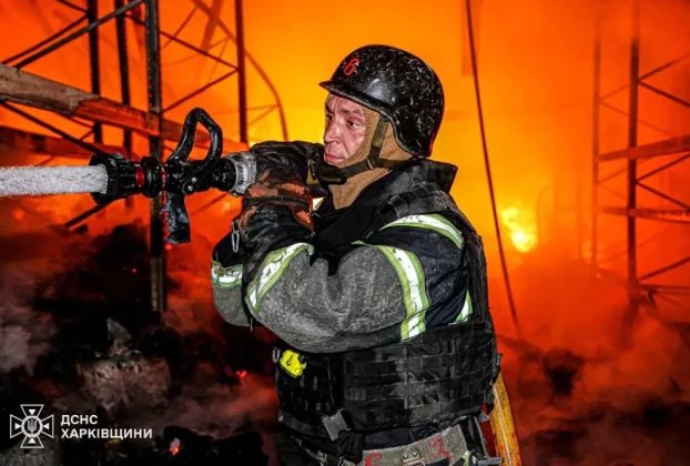 Український пожежний гасить пожежу після удару Росії ракетами по місту Харків