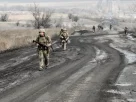 Українські військові йдуть по дорозі до своїх позицій