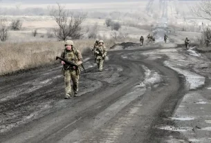 Українські військові йдуть по дорозі до своїх позицій