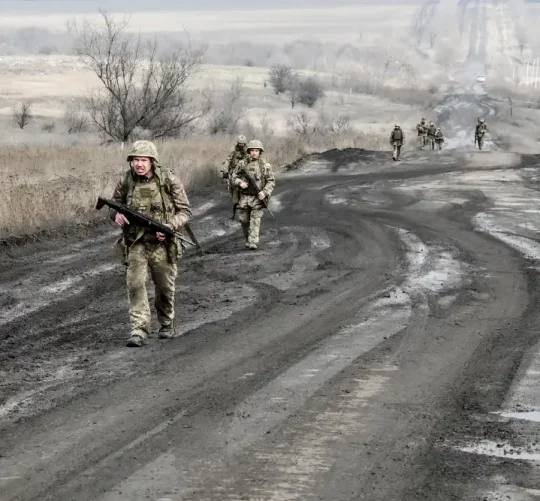 Українські військові йдуть по дорозі до своїх позицій