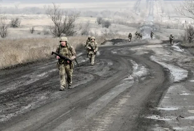 Українські військові йдуть по дорозі до своїх позицій