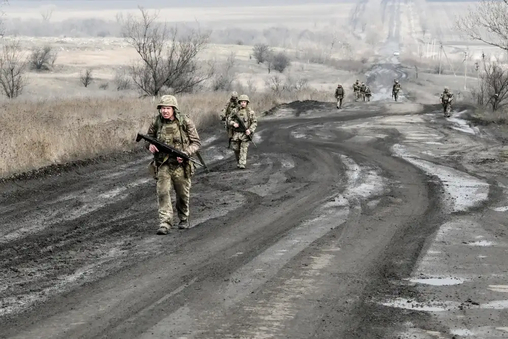 Українські військові йдуть по дорозі до своїх позицій