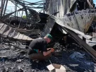 Мешканець перебирає попіл на місці зруйнованого міського ринку після недавнього російського ракетного удару по Києву, 24 червня 2026 року