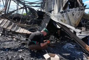 Мешканець перебирає попіл на місці зруйнованого міського ринку після недавнього російського ракетного удару по Києву, 24 червня 2026 року
