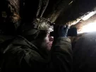 солдат у бліндажі дивиться у бінокль