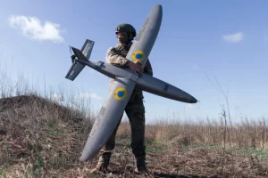 Солдат з підрозділу БЛА «Тайфун» ЗСУ тримає в руках ударний дрон «Марсіанін» у Харківській області