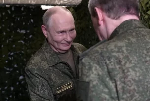 Путін у військовій формі посміхається генералу