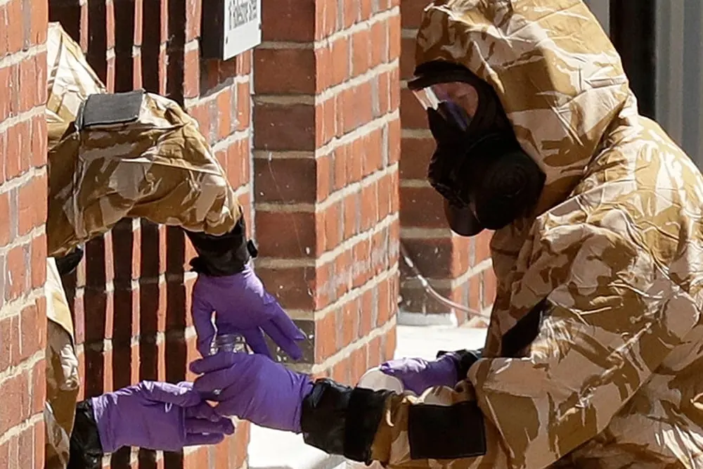 Члени спеціалізованої групи у військових захисних костюмах під час операції з очищення від нервово-паралітичного речовини «Новічок» у Солсбері, 6 липня 2018 року