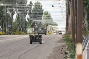 20 червня 2026 року в Донецькій області, Україна, наземний дрон рухається вздовж дороги, захищеної сітками проти дронів
