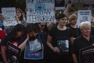 Люди тримають плакати біля російського посольства в Києві, 29 липня 2023 року