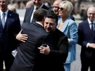Президент Франції Еммануель Макрон обіймає президента України Володимира Зеленського після щорічного військового параду з нагоди Дня взяття Бастилії, що відбувся у вівторок у Парижі