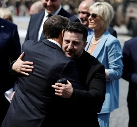 Президент Франції Еммануель Макрон обіймає президента України Володимира Зеленського після щорічного військового параду з нагоди Дня взяття Бастилії, що відбувся у вівторок у Парижі