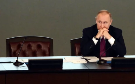 Володимир Путін сидить за столом з порожнім поруч місцем