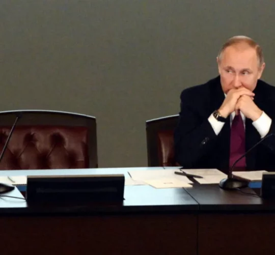 Володимир Путін сидить за столом з порожнім поруч місцем