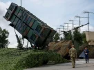 Українські військовослужбовці йдуть поруч із пусковою установкою системи протиповітряної оборони «Патріот»