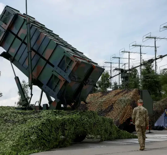 Українські військовослужбовці йдуть поруч із пусковою установкою системи протиповітряної оборони «Патріот»