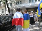 люди обгорнуті у прапори Польщі та України стоять поручь