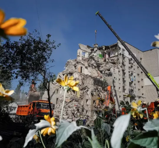 Рятувальники працюють на місці житлового будинку, пошкодженого під час російського ракетного та безпілотного удару в по Києву