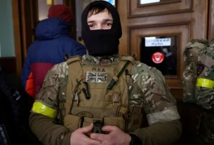Іноземний військовий із Великої Британії позує для фотографії, коли він та інші добровольці готуються вирушити на лінію фронту на сході України