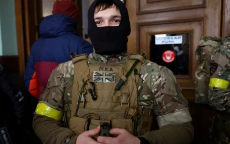 Іноземний військовий із Великої Британії позує для фотографії, коли він та інші добровольці готуються вирушити на лінію фронту на сході України