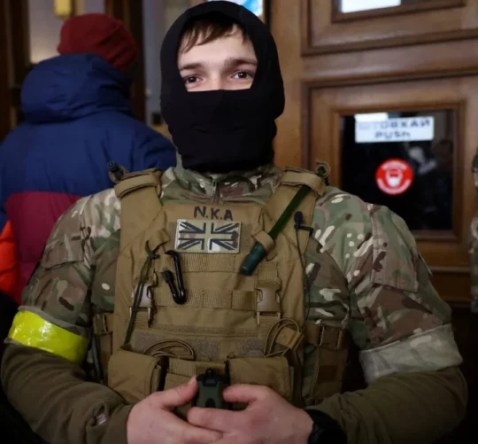 Іноземний військовий із Великої Британії позує для фотографії, коли він та інші добровольці готуються вирушити на лінію фронту на сході України