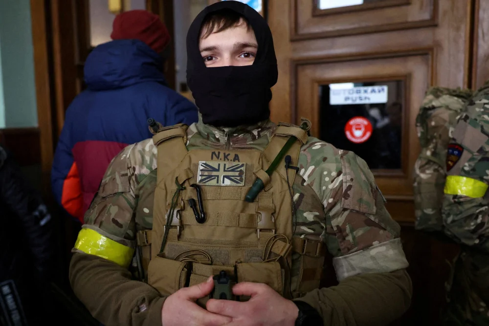 Іноземний військовий із Великої Британії позує для фотографії, коли він та інші добровольці готуються вирушити на лінію фронту на сході України
