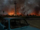 Вогонь і дим піднімаються зі складу, зруйнованого під час масштабних ударів російських балістичних ракет і дронів на околицях Києва рано вранці 5 серпня 2026 року